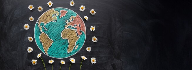 The Globe Made of Colorful Chalk Surrounded by Fresh Daisies on Blackboard

