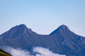 Twin mountain peaks rising above low clouds viewed from Zawrat Pass in the Tatra Mountains