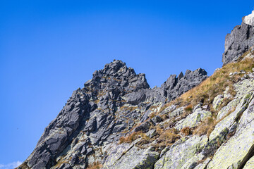 Rocky mountain summit and sharp ridgeline under clear blue sky