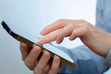 A woman works with a smartphone in the office, on a report. Close-up of her hands. 	