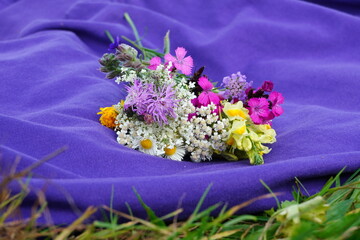 Closeup of colorful wild flowers bouquet on purple cloth