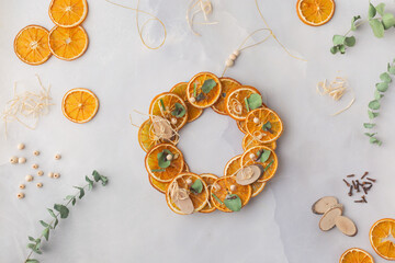 A decorative wreath crafted from dried orange slices, eucalyptus leaves, dried cloves, wooden cuts step by step instruction diy