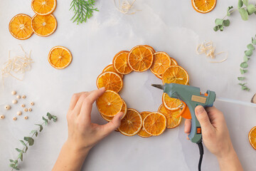 A decorative wreath crafted from dried orange slices, eucalyptus leaves, dried cloves, wooden cuts step by step instruction diy