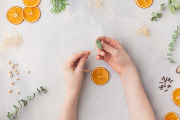 Christmas toy made from dried orange slices, wooden beads and eucalyptus leaves festive holiday interior