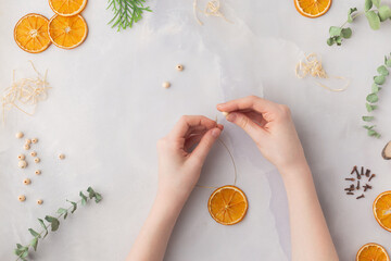 Christmas toy made from dried orange slices, wooden beads and eucalyptus leaves festive holiday interior