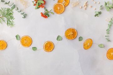 Christmas toy made from dried orange slices, wooden beads and eucalyptus leaves festive holiday interior