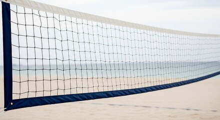 Close up of a beach volleyball net with sandy beach and ocean in the background, a concept of summer vacation and beach sport.