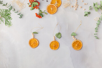 Christmas toy made from dried orange slices, wooden beads and eucalyptus leaves festive holiday interior