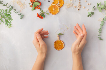 Christmas toy made from dried orange slices, wooden beads and eucalyptus leaves festive holiday interior