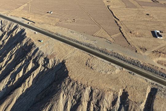 Highway construction process along the edge of desert cliffs