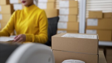 Small business owners packing boxes and preparing shipping labels together in warehouse office