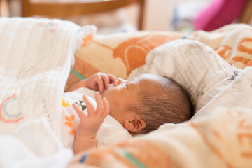 ベビーベッドで眠る日本人の男の子の乳児
