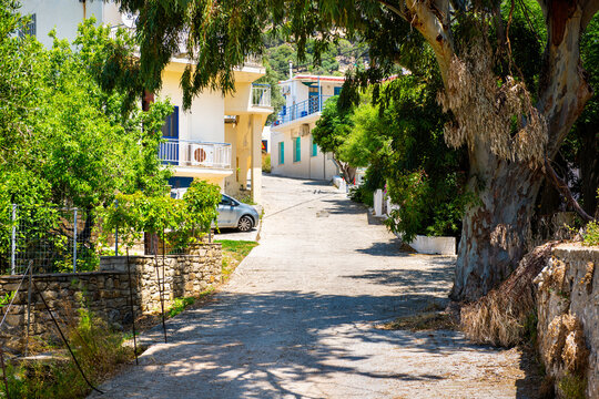 Karkinagri greek village narrow road street alley uphill with houses homes in longevity blue zone of Ikaria island, Greece summer