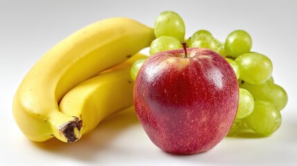 A vibrant red  sits with bright yellow bananas and green grapes.