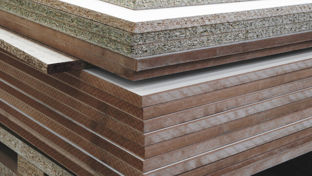 Stacks of cut chipboard panels lie in a furniture transport factory or in a distribution warehouse for storage and delivery