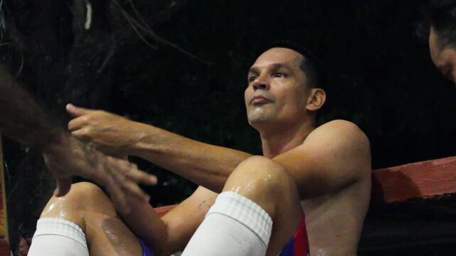 A Colombian man sits drinking water to hydrate after playing a soccer match on a field in Neiva, Huila, Colombia. Concept of hydration and rest