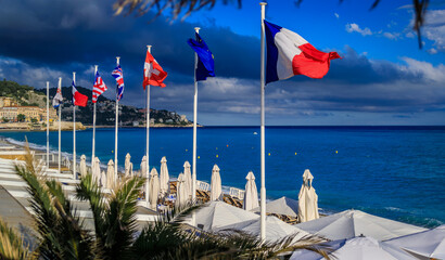 International flags over beach umbrellas and the Mediterranean Sea, Nice, France