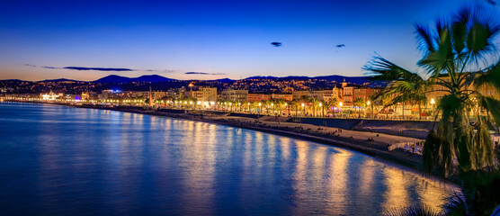 Promenade des Anglais illuminated by warm evening lights at sunset, Nice, France