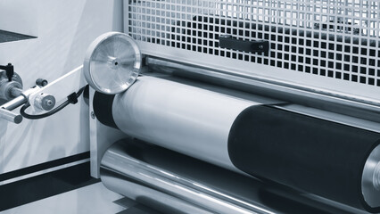 Brown recycled kraft paper roll is passed through the machine for printing and producing gift packaging bags for sale, packaging delivery logistics concept background.