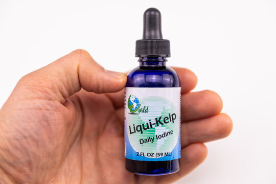 Naples, USA - May 4, 2022: Iodine liquid kelp form bottle dietary nutrition mineral supplement macro closeup of hands holding