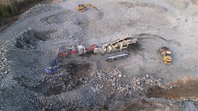 Espoo, Finland-April 14, 2025: Rock processing heavy machinery operating in quarry during springtime, transforming granite and basalt into crushed stone for construction and infrastructure development