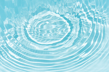 Blue water with ripples on the surface. Defocus blurred transparent blue colored clear calm water surface texture with splashes and bubbles. Water waves with shining pattern texture background.