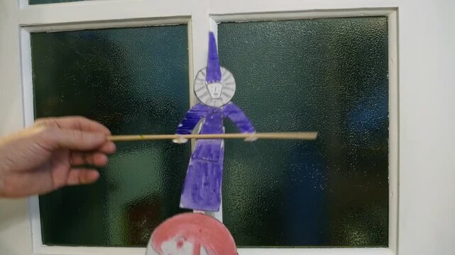 paper clown equilibrist with a pole paper toy in human hands