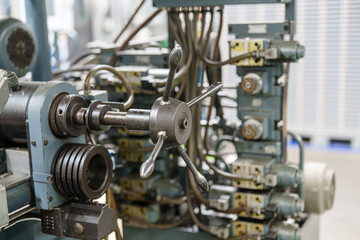 Control panel with manual wheel and connected machinery in a manufacturing facility during daytime