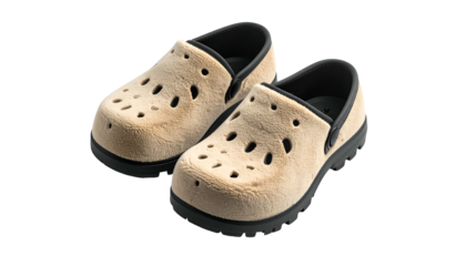 Pair of fluffy, tan slip-on shoes with black soles and inner lining, isolated