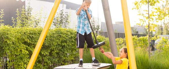 Happy little kids brother and sister on the playground