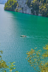 Beautiful panoramic view of Lake K&ouml;nigssee, with tourists in a small rowboat.
