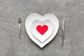 Table setting for Valentine's Day with paper heart on grey grunge background