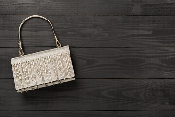 Fototapeta premium Handbag with beads on wooden background, top view