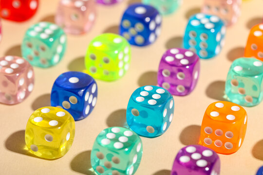 Colorful game dices on beige background, closeup