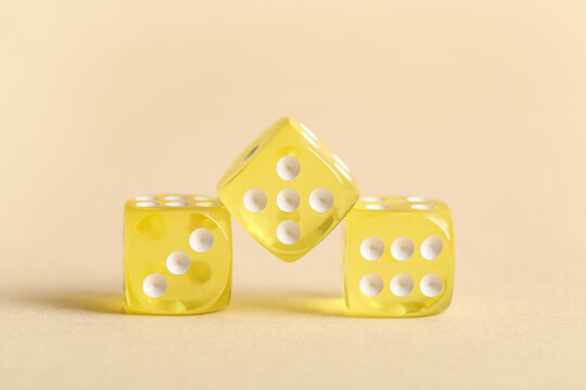 Yellow game dices on beige background
