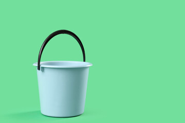 Blue plastic bucket on green background © Pixel-Shot