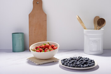 Containers with fresh strawberries and blueberries.