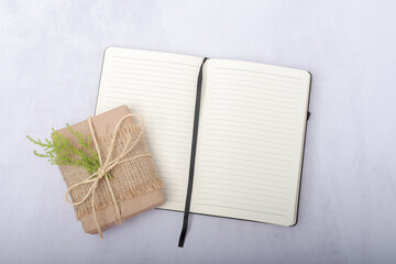 Gift with rustic wrapping and notepad with copy space.