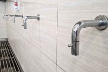 Modern Minimalist Stainless Steel Water Taps inside ablution or wudhu room inside the mosque,...