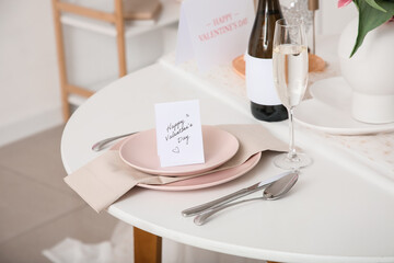 Beautiful table setting with greeting card and wine, closeup. Valentine's Day celebration
