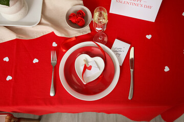Beautiful table setting with clean plates, greeting cards and roses, closeup. Valentine's Day...