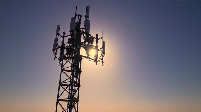 Mobile phone communication radio antenna, 3G, 4G, 5G. Aerial view of antenna in golden hour sky at summer. Cellular GSM tower with transmitter. Telecommunication base station network. Internet and dat
