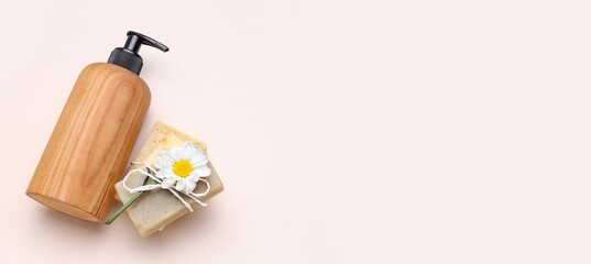 Bottle of cosmetic product, soap and chamomile on light background with space for text