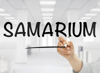 A conceptual image featuring the word "Amarium" handwritten in bold black letters on transparent glass, with a blurred modern white office in the background, representing this rare earth metal