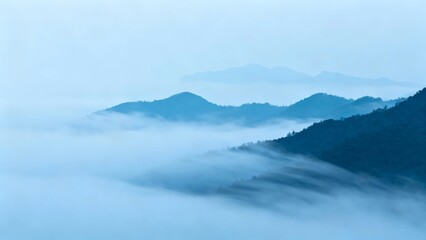 Mountain peaks emerging from a sea of mist under a soft blue sky