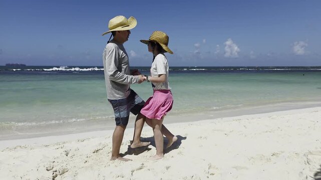Father teaching her daughter to dance salsa in the beach. Family and education concept