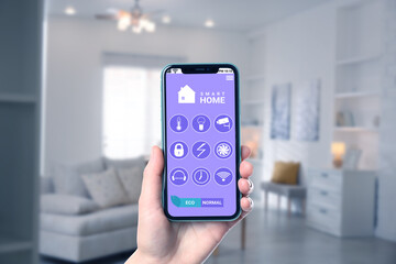 Smart home system. Man using app on mobile phone to control house features in room, closeup