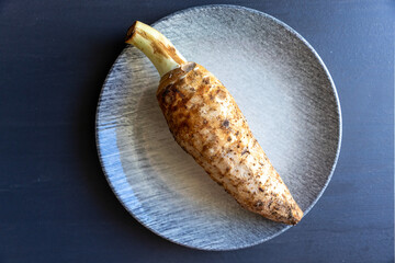 Kolokasi or taro root on plate top view. It is a starchy root vegetable that is widely enjoyed in Cyprus simmered dishes and hearty soups.