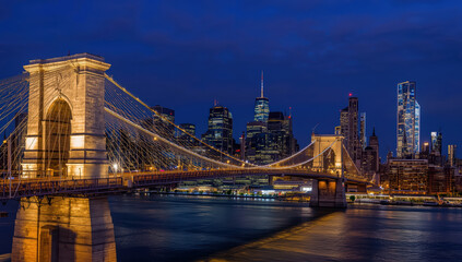Fototapeta premium Brooklyn bridge skyline night lights reflecting on river, tranquil urban evening
