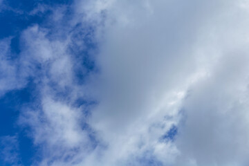 Aerial view of a bright blue sky filled with soft white clouds, creating a calm and open atmosphere ideal for weather concepts, natural backgrounds, seasonal transitions, or clean visual backdrops.